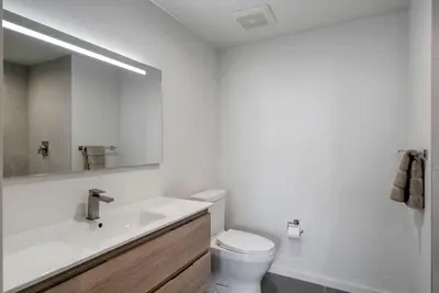 a bathroom with a sink and a toilet and a mirror at Blueground Wynwood pool gym nr Design Dist MIA-99 in Miami