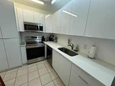 a white kitchen with a sink and a stove at Lovely 2 bedroom with side ocean view in Hollywood
