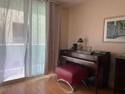 a room with a piano and a red stool next to a window at Lovely 2 bedroom with side ocean view in Hollywood