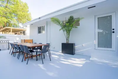 a patio with a table and chairs and a plant at 5BR HotTubPoolTableMiniGolf 7 min to Wynwood in Miami