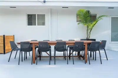 a table and chairs in a room with a plant at 5BR HotTubPoolTableMiniGolf 7 min to Wynwood in Miami