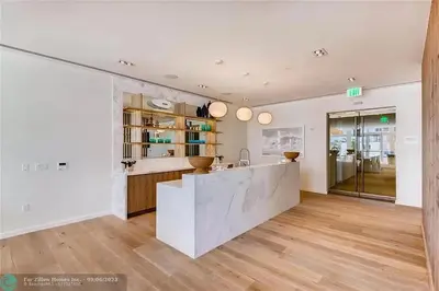 a kitchen with white walls and wooden floors and a counter at The Glamour of Upscale Downtown Ft. Lauderdale in Fort Lauderdale