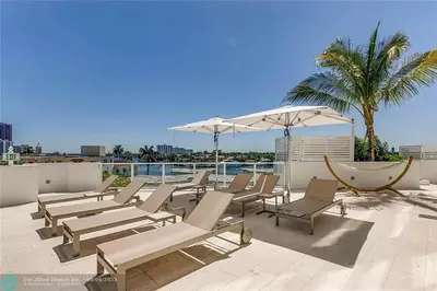 a row of lounge chairs and an umbrella on a rooftop at The Glamour of Upscale Downtown Ft. Lauderdale in Fort Lauderdale