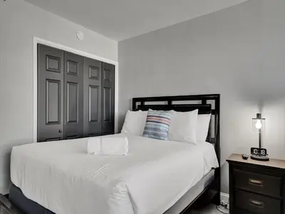a bedroom with a white bed and a black door at Cozy Beachfront 2 Bedroom Condo Beach Service 406 in Miami Beach