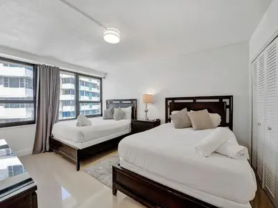 a white bedroom with two beds and a window at Cozy Beachfront 2 BDR Miami Beach Condo 1516 in Miami Beach