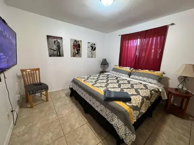 a bedroom with a bed and a tv and a chair at 2 Bedroom Boutique Gem 10 min to the beach Washer Dryer Gated Parking Bliss 2 in Hollywood