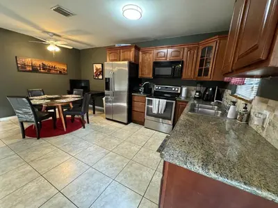 a kitchen with stainless steel appliances and a table at 2 Bedroom Boutique Gem 10 min to the beach Washer Dryer Gated Parking Bliss 2 in Hollywood