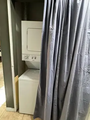 a bathroom with a shower curtain next to a washing machine at 2 Bedroom Boutique Gem 10 min to the beach Washer Dryer Gated Parking Bliss 2 in Hollywood