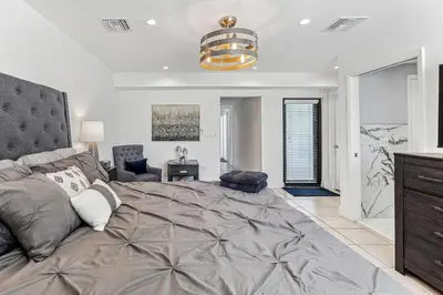 a bedroom with a large bed and a living room at Miami Oasis, Spacious 4-Bedroom Home with Pool in Miami