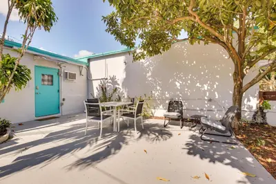 a patio with a table and chairs under a tree at Near Haulover Park Hollywood Cottage with Yard! in Hollywood