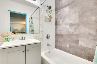 a bathroom with a sink and a tub and a shower at Near Haulover Park Hollywood Cottage with Yard! in Hollywood
