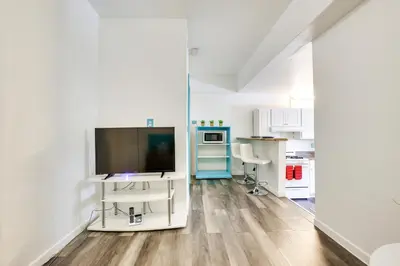a living room with a tv and a kitchen at Near Haulover Park Hollywood Cottage with Yard! in Hollywood
