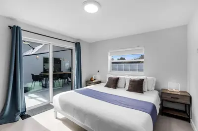 a white bedroom with a large bed and a balcony at Stylish 4 Bedroom Home with Pool, 12 Minutes to the beach in Miami
