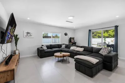 a living room with a couch and a table at Stylish 4 Bedroom Home with Pool, 12 Minutes to the beach in Miami