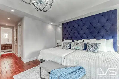 a bedroom with a large bed with a blue headboard at Victoria Villa - Walk to Las Olas - 4 Bed 4 Bath in Fort Lauderdale