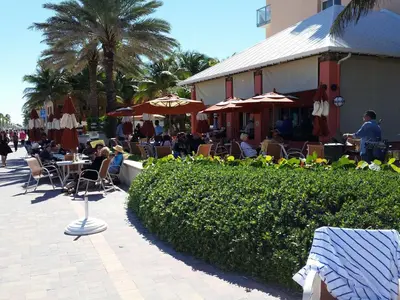 a group of people sitting at tables in an outdoor restaurant at Hollywood Broadwalk Oceanside Hotel in Hollywood