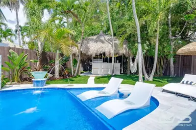 a swimming pool with two white chairs and a resort at Floridita 5Bed 4Bath FTL Paradise with Tiki Hut Heated Pool in Fort Lauderdale