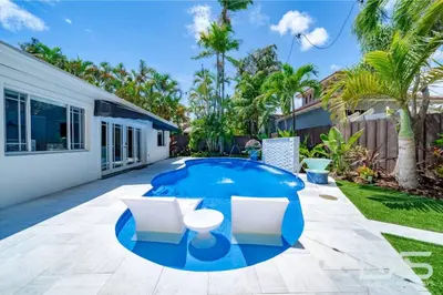 a swimming pool in the backyard of a house at Floridita 5Bed 4Bath FTL Paradise with Tiki Hut Heated Pool in Fort Lauderdale