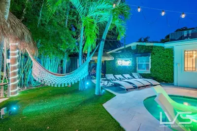 a backyard with a hammock and a swimming pool at Floridita 5Bed 4Bath FTL Paradise with Tiki Hut Heated Pool in Fort Lauderdale