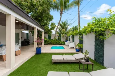 a backyard with a pool and green grass at D'Mauchi House in Miami