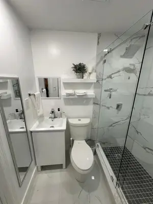 a white bathroom with a toilet and a shower at Adrien Guest Studio in Miami Gardens