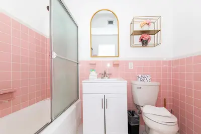 a pink bathroom with a toilet and a sink at Art Deco Washingthon Apartment in Miami Beach