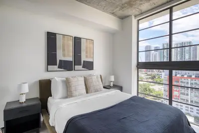 a bedroom with a bed and a large window at Blueground Wynwood gym roof pool nr Midtown MIA-101 in Miami