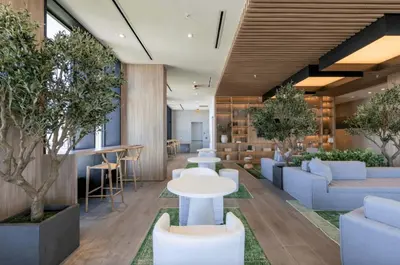 a lobby with white tables and chairs and trees at Blueground Wynwood gym roof pool nr Midtown MIA-101 in Miami