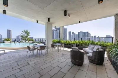 an outdoor patio with a view of a city skyline at Blueground Wynwood gym roof pool nr Midtown MIA-101 in Miami