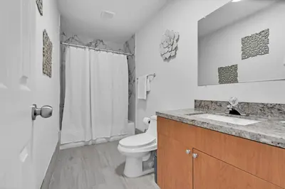 a white bathroom with a toilet and a sink at Chic Miami Private Pool Home in Cutler Ridge