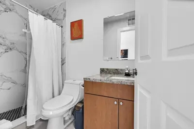 a white bathroom with a toilet and a sink at Chic Miami Private Pool Home in Cutler Ridge