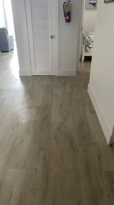 a living room with a wooden floor and white walls at Cozy newly furnished apartment , on the 6th floor. in Sunny Isles Beach