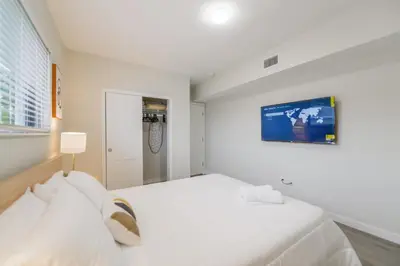 a white bedroom with a large white bed in it at Prime Location Apartment at Calle Ocho in Miami