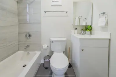 a white bathroom with a toilet and a sink and a tub at Prime Location Apartment at Calle Ocho in Miami
