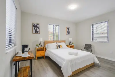 a white bedroom with a bed and a table at Prime Location Apartment at Calle Ocho in Miami