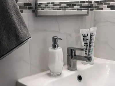 a bathroom sink with a soap dispenser on it at Cozy Studio Apartment in Miami