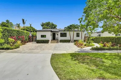 a white house with a garden and a driveway at Casa Coral with Pool Charcoal BBQ area in Miami