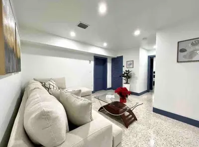 a living room with a white couch and a table at Renovated Grand Villa Paradise Amazing pool, BBQ & Ping Pong in Tamiami