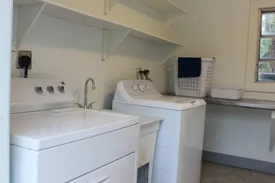a laundry room with a sink and a washing machine at Sunny Resort Oasis with Heated Pool Ping Pong in Tamiami