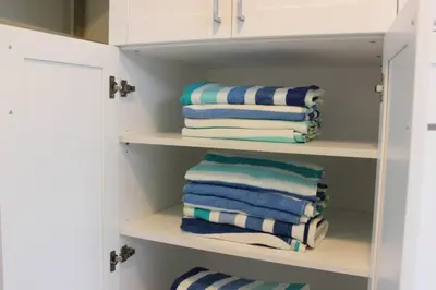 a closet with blue and white towels on shelves at Sunny Resort Oasis with Heated Pool Ping Pong in Tamiami