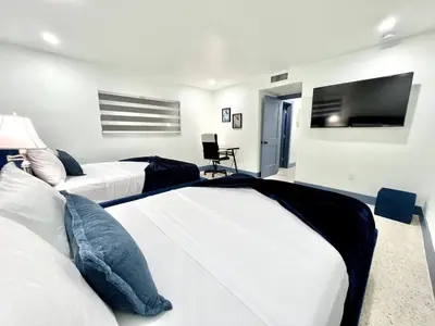 a bedroom with two beds and a flat screen tv at Sunny Resort Oasis with Heated Pool Ping Pong in Tamiami