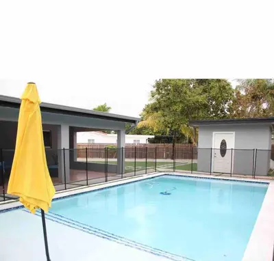 a swimming pool with a yellow umbrella next to it at Miami dream resort heated pool sleeps 8 in Tamiami