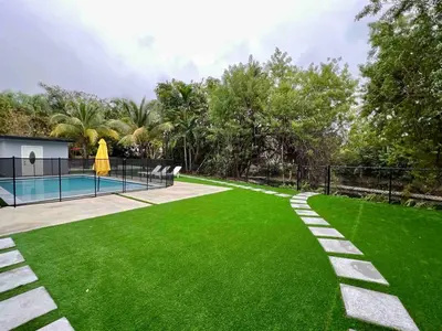 a green yard with a swimming pool and a fence at Miami dream resort heated pool sleeps 8 in Tamiami