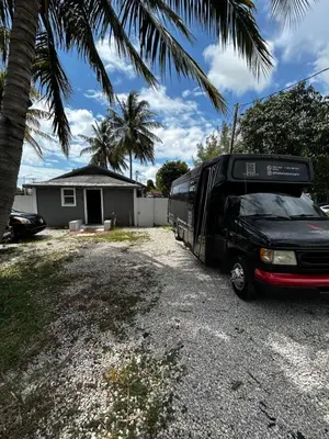 a black bus parked in front of a house at The Black Door miami in Miami