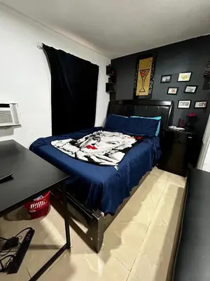 a bedroom with a bed with blue sheets and a table at The Black Door miami in Miami