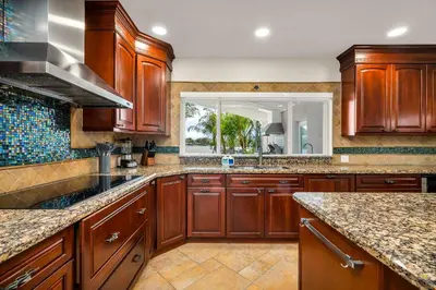 a kitchen with wooden cabinets and a large window at Tropical Waterfront Family Oasis - Amazing Location in Miami
