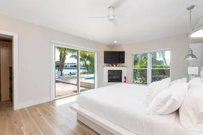 a white bedroom with a large bed and a fireplace at Tropical Waterfront Family Oasis - Amazing Location in Miami