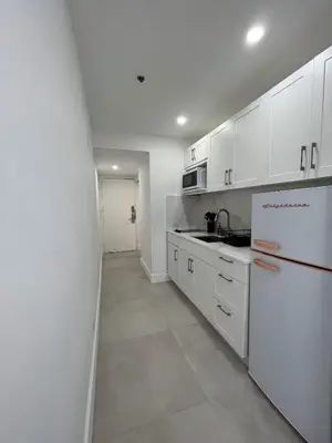 a kitchen with white cabinets and a white refrigerator at Shaomi South Beach in Miami Beach