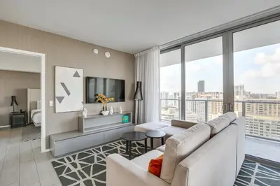 a living room with a couch and a large window at Walk to Hollywood Beach Upscale 16th-Floor Condo in Hollywood