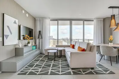 a living room with a couch and a table at Walk to Hollywood Beach Upscale 16th-Floor Condo in Hollywood
